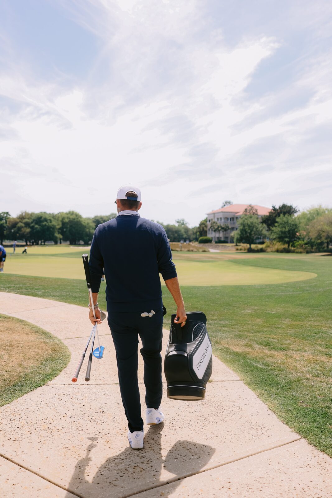 Billy Belair walking the fairway at Grande Dunes carrying his Pinehurst staff bag